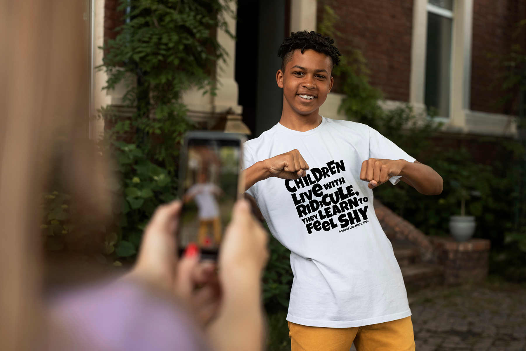 “If children live with ridicule, they learn to feel shy” – White  (Bella+Canvas) T-shirt